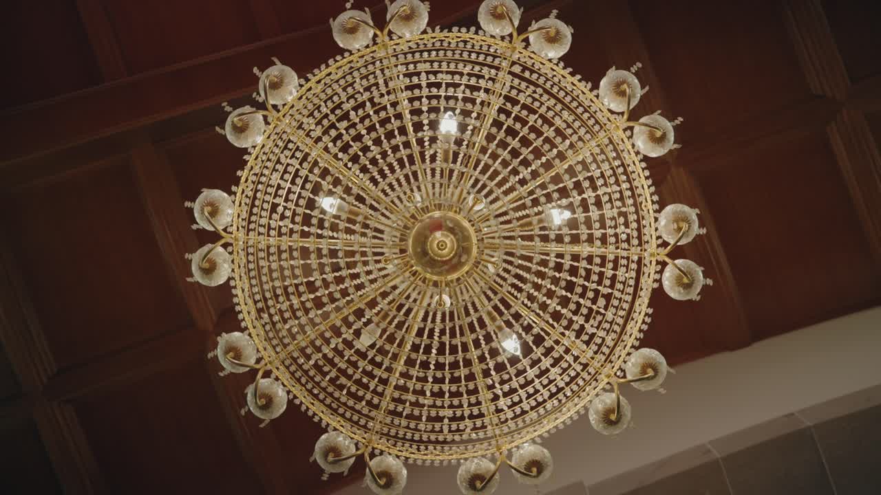 Elegant golden chandelier with crystals viewed from below