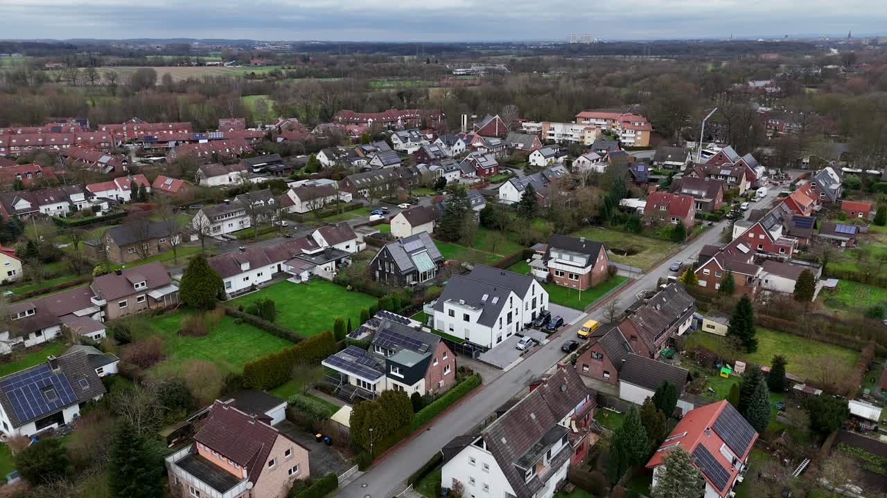 Aerial wide shot of single family houses with solar panels in small american town during winter season. Different houses and homes in rural countryside. Renewable energy on cloudy day.