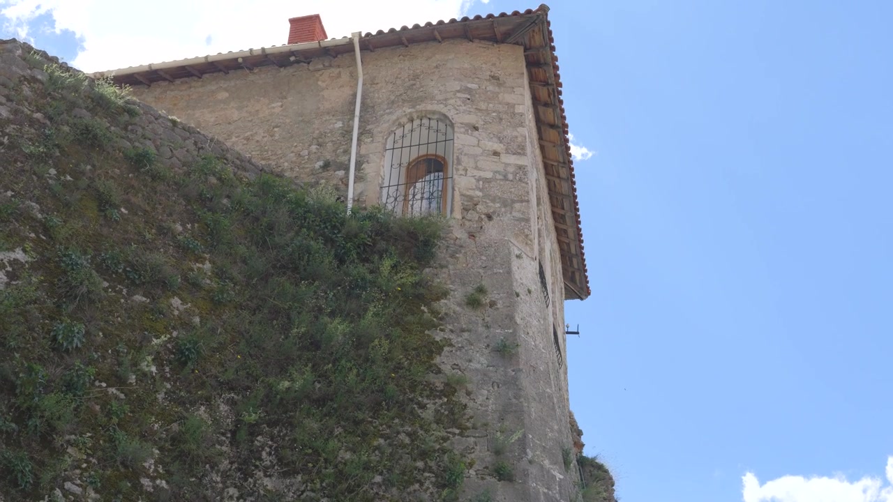 Edificio in pietra della Fortezza di Kruja con finestra ad arco sbarrata e tetto in tegole sopra il bastione, Albania