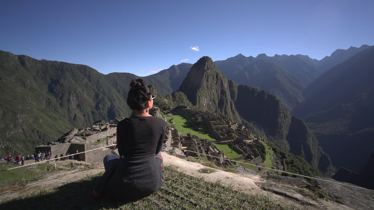una mujer asiática admirando la vista del majestuoso macchu picchu en perú justo delante de ella