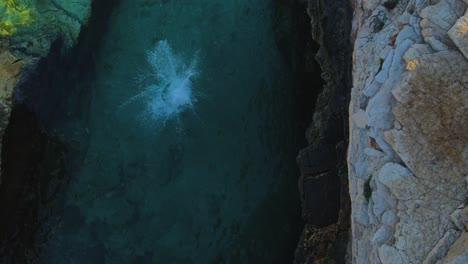 Explore-this-extraordinary-perspective-of-a-cliff-diver,-as-they-immerse-themselves-in-the-shimmering,-vivid,-deep-blue-lake---it-generates-a-deeply-profound-sensation