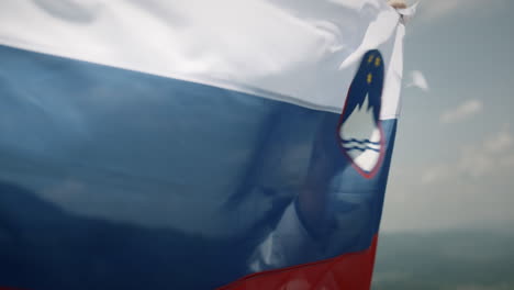 Man-holds-up-a-Slovenian-flag-to-flutter-in-the-wind