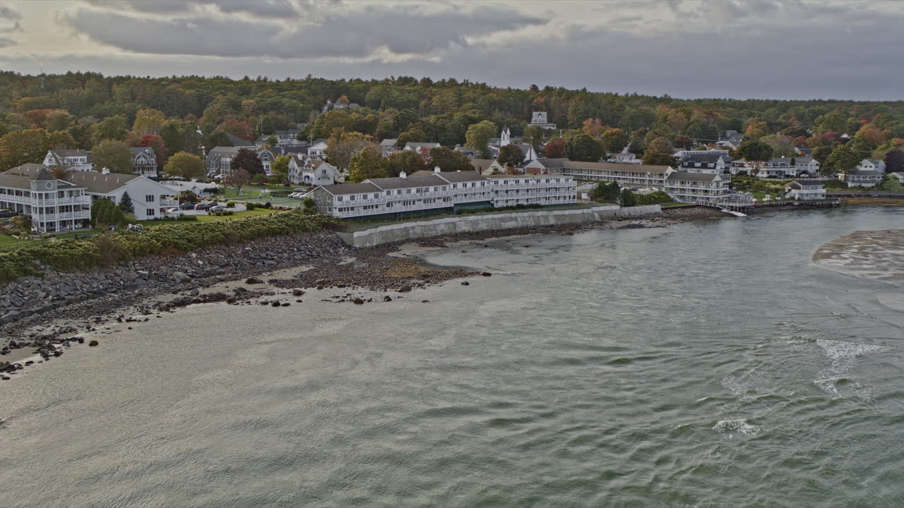 Ogunquit Maine Udara v5 terbang rendah di atas pantai berbatu, menangkap pemandangan kota yang indah dengan pemandangan pantai dan matahari bersinar di permukaan air sungai - Direkam dengan kamera Inspire 2, X7 - Oktober 2021.