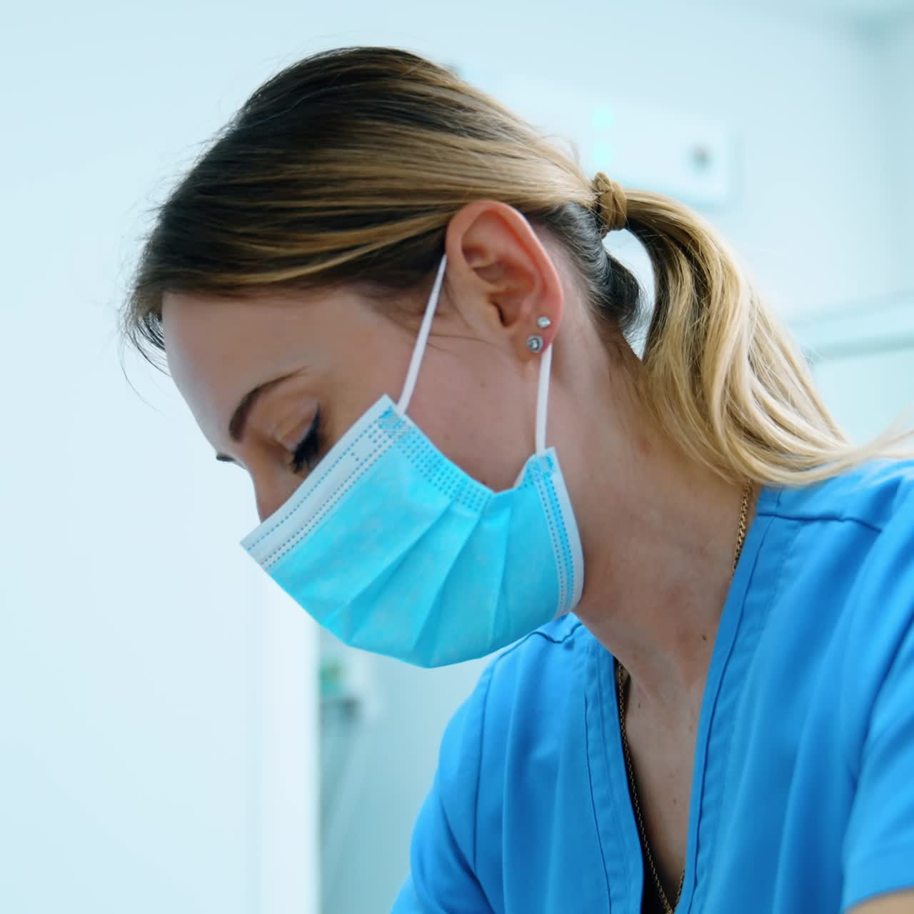Médica de máscara se inclina sobre o bebê recém-nascido. Enfermeira trabalhando na sala de parto. Close-up