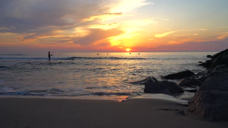 ejercicio temprano en la mañana en la playa, surf de remo de silueta desde la playa al amanecer