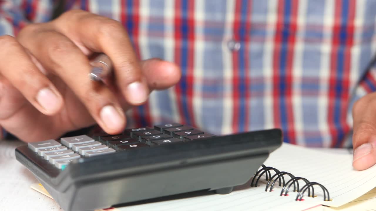 primer plano de la mano del hombre usando una calculadora