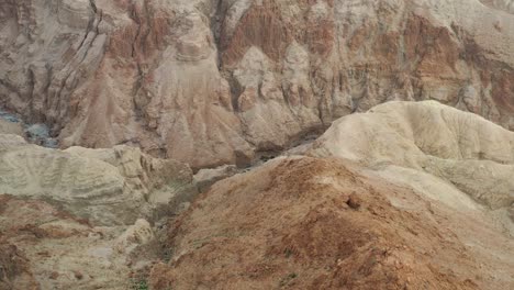 Aerial-fly-over-a-creek-between-red-desert-mountains-in-Israel-Judea-desert