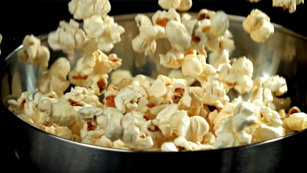 Popcorn che cadono al rallentatore in una ciotola di metallo