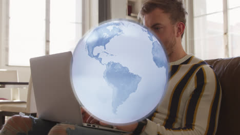 animation of globe spinning over caucasian man using laptop