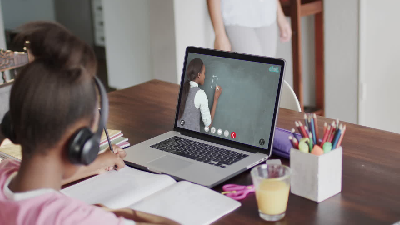 composición de una colegiala afroamericana en una computadora portátil aprendiendo en línea con una maestra