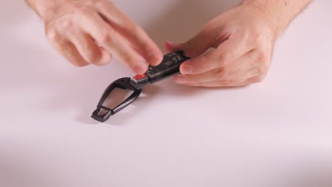 hands peel take off casing of key fob to separate parts, batteries, and circuit board