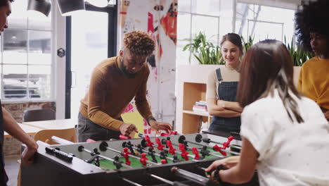los creativos empresariales del milenio toman un descanso jugando al fútbol de mesa en el trabajo