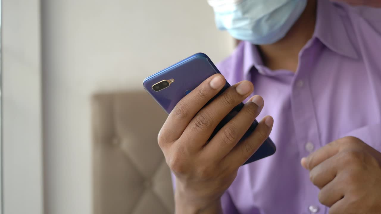 persona que usa un teléfono inteligente mientras lleva una máscara