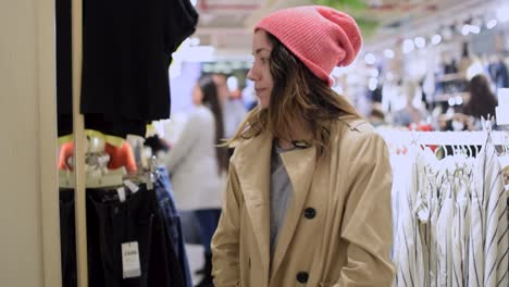 young woman trying a coat in a shopping mall