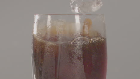 Primer-Plano-De-Cubitos-De-Hielo-Cayendo-En-Un-Vaso-De-Cola-En-Cámara-Lenta---240-Fps