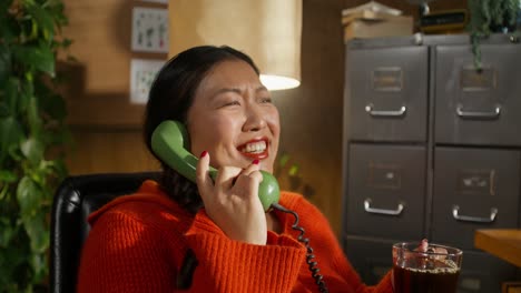 mujer hablando en teléfono vintage en la oficina de casa