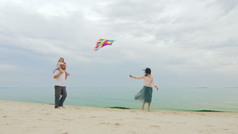 friendly young family playing with daughter fly a kite 03