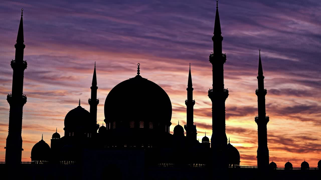 Un video ipnotico che cattura la silhouette di una moschea sullo sfondo di un cielo al tramonto dai colori vivaci