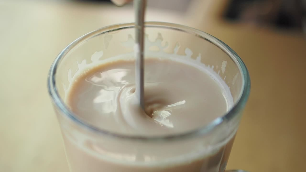 Rör om en latte i ett glas