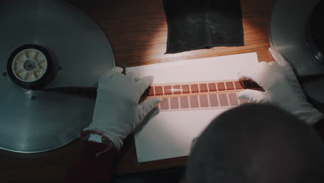 a man working at a film studio, works with old film strip