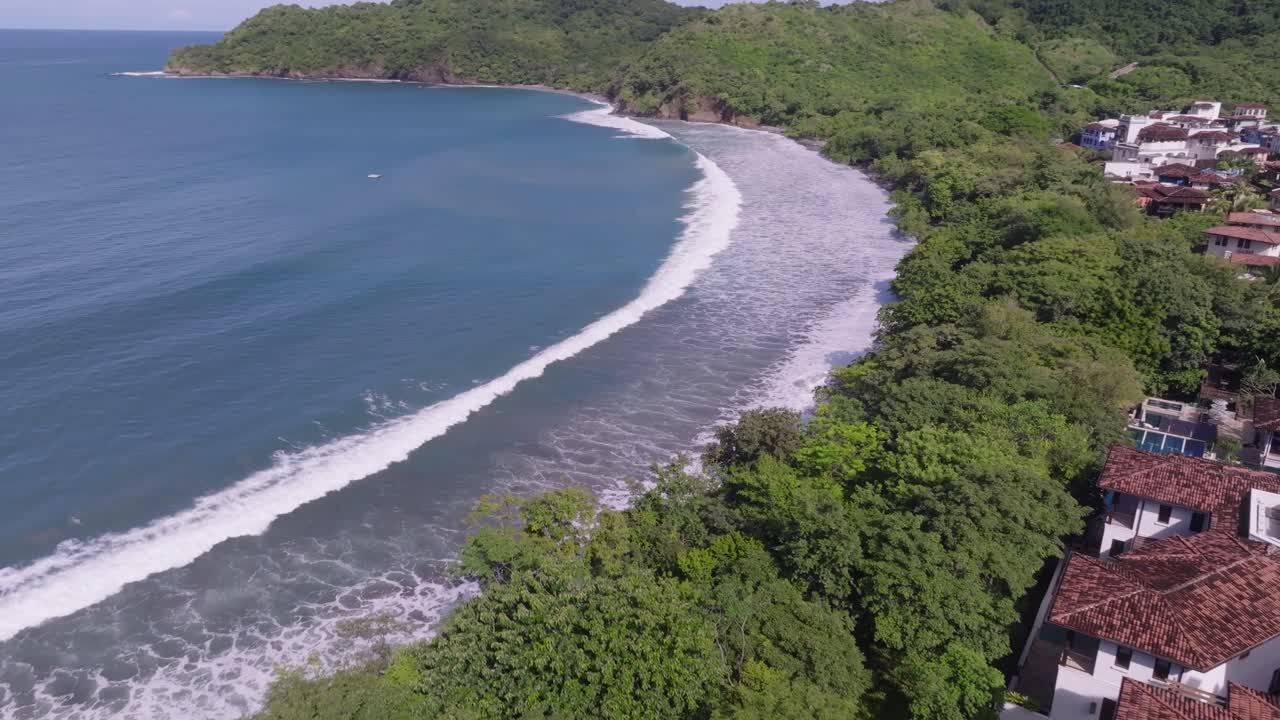 Las Catalinas, Guanacaste Province in Costa Rica showing homes, mountains and ocean with drone video spinning around