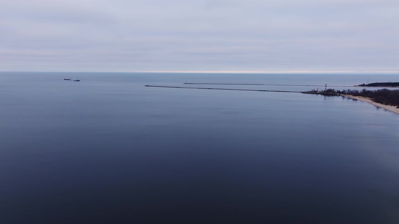 Forward drone flight over Daugavgriva Beach and Riga Gulf breakwater in Latvia