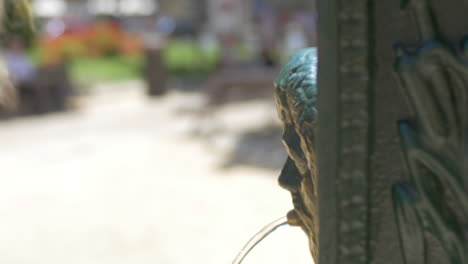 View-of-young-blond-woman-in-black-sunglasses-drinking-from-old-public-fountain-Valencia-Spain