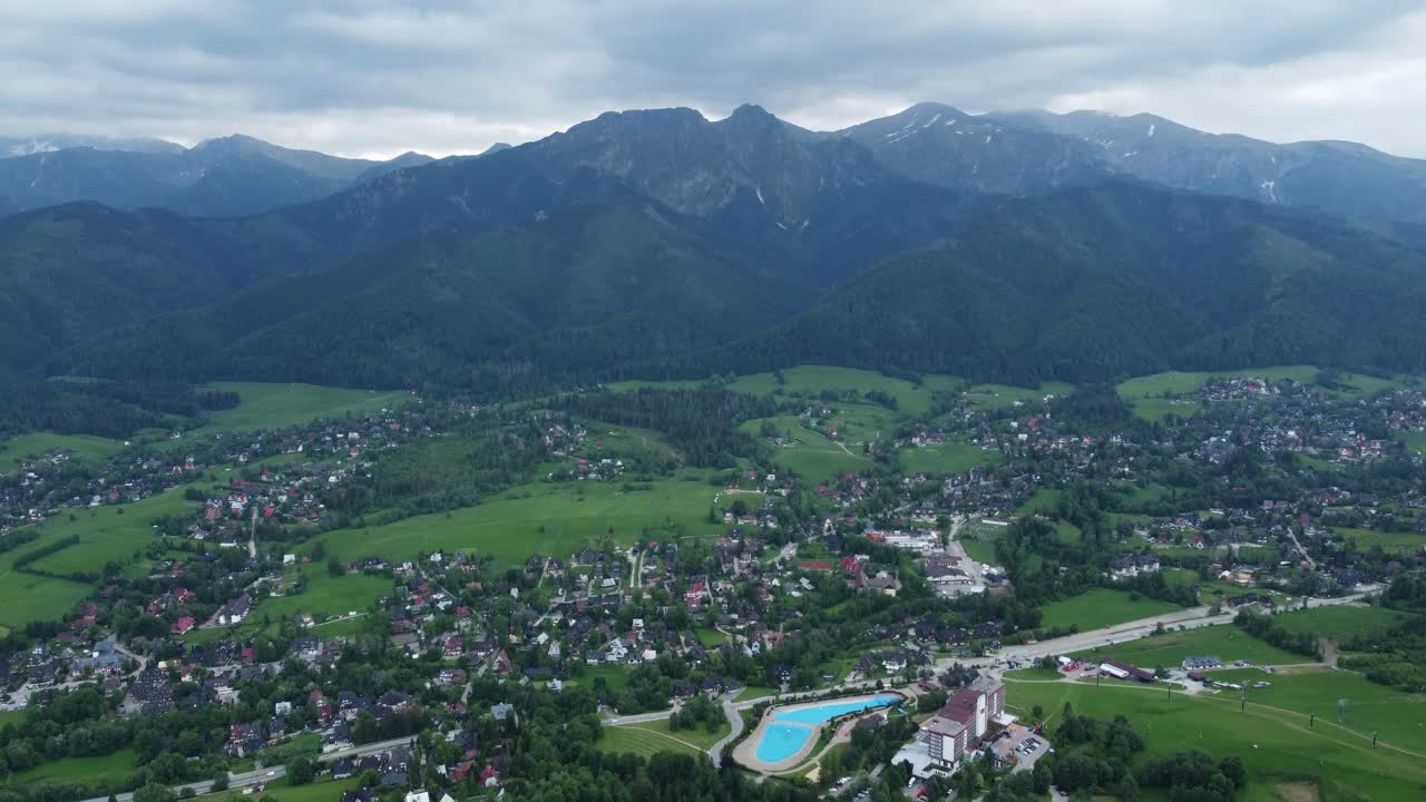 Valley view from Gubałówka - landscape flyover of snowcapped Polish Tatry Mountains, farmland, forests, and legendary Giewont peak near Zakopane, Poland - 4K 30FPS Smooth Tracking Forward-4