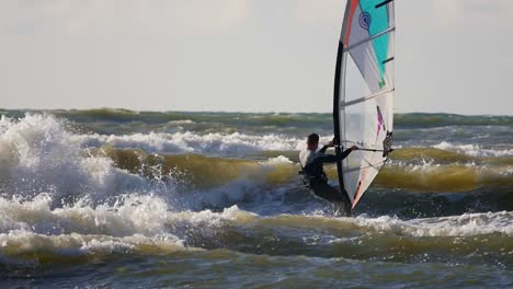 male windsurfer on high ocean waves