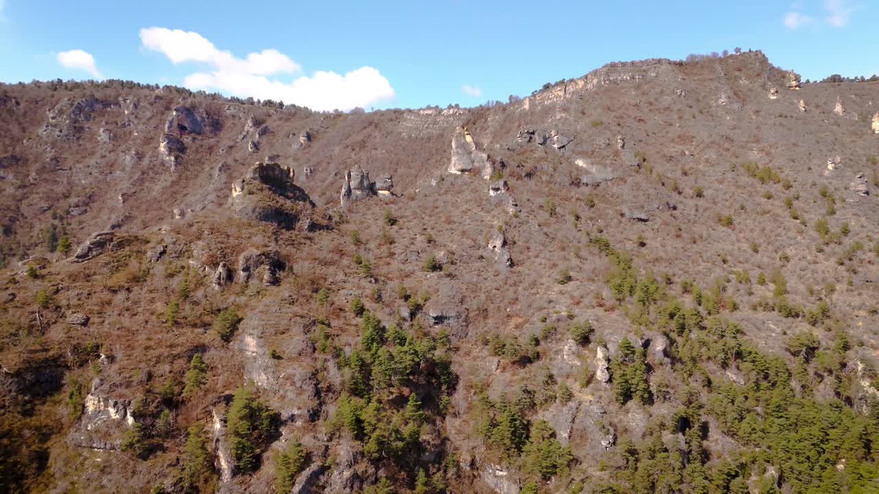 establishing shot of stone pillars on the steep mountain terrain at Lozère