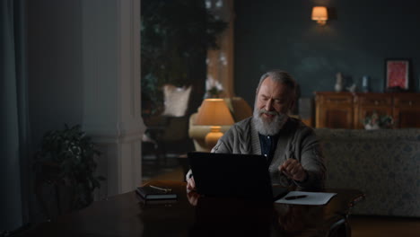 Senior-business-man-finishing-work-on-laptop-computer-in-vintage-cabinet