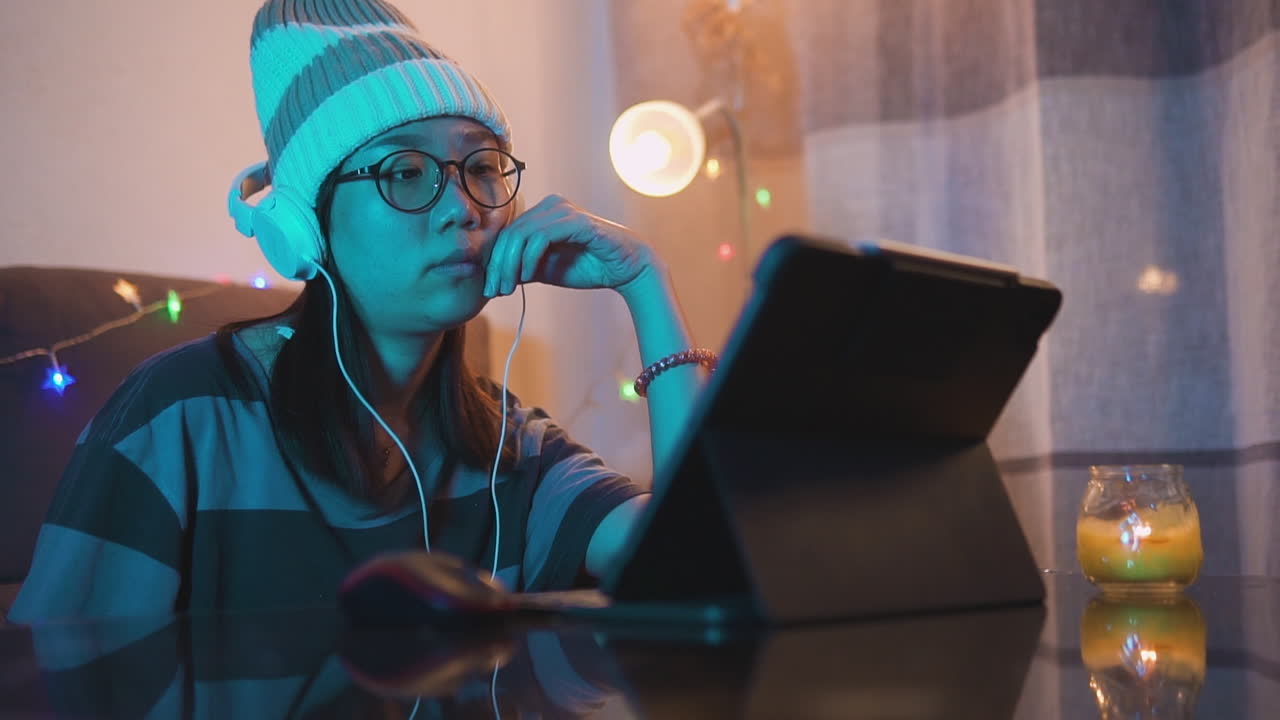 chica asiática escuchando y sintiendo la música con auriculares y una computadora