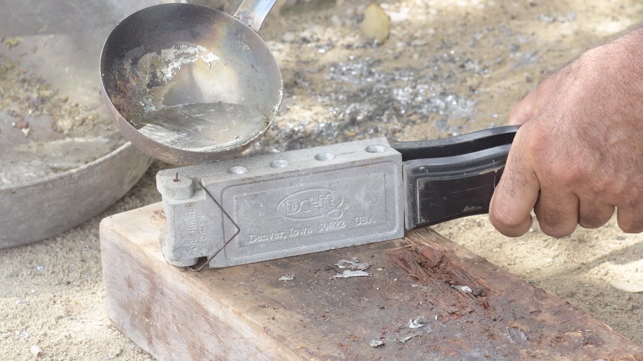 primer plano de plomo fundido vertiendo en el molde, la mano del artesano a la vista, artesanía detallada, luz del día