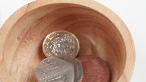 uk currency pounds sterling coins falling and spinning in slow motion close up rotating footage against the white background