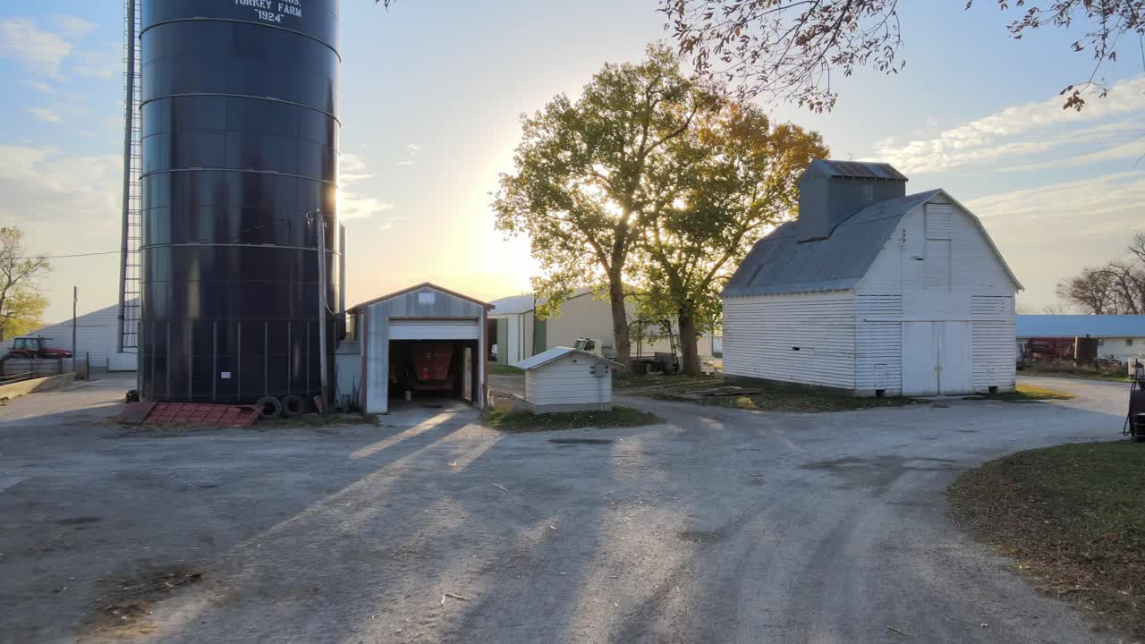 Aerial Drone Footage Flying Through A Farmyard, Passing Barns, Buildings, Farm Equipment, Tractors In Midwestern, Iowa