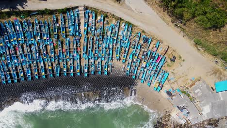 Un-Sinfín-De-Barcos-De-Pescadores-Tradicionales-Azules-En-Menganti,-Vista-Aérea-De-Arriba-Hacia-Abajo