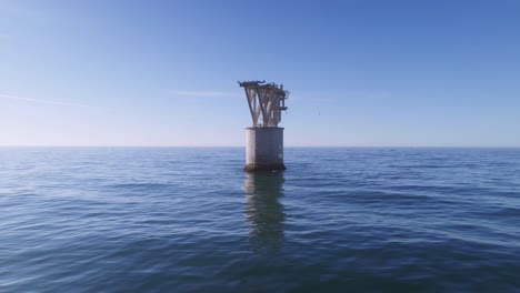 Drone-flying-away-from-an-abandoned-tower-near-the-beach-of-Playa-del-Cable,-Marbella,-Spain