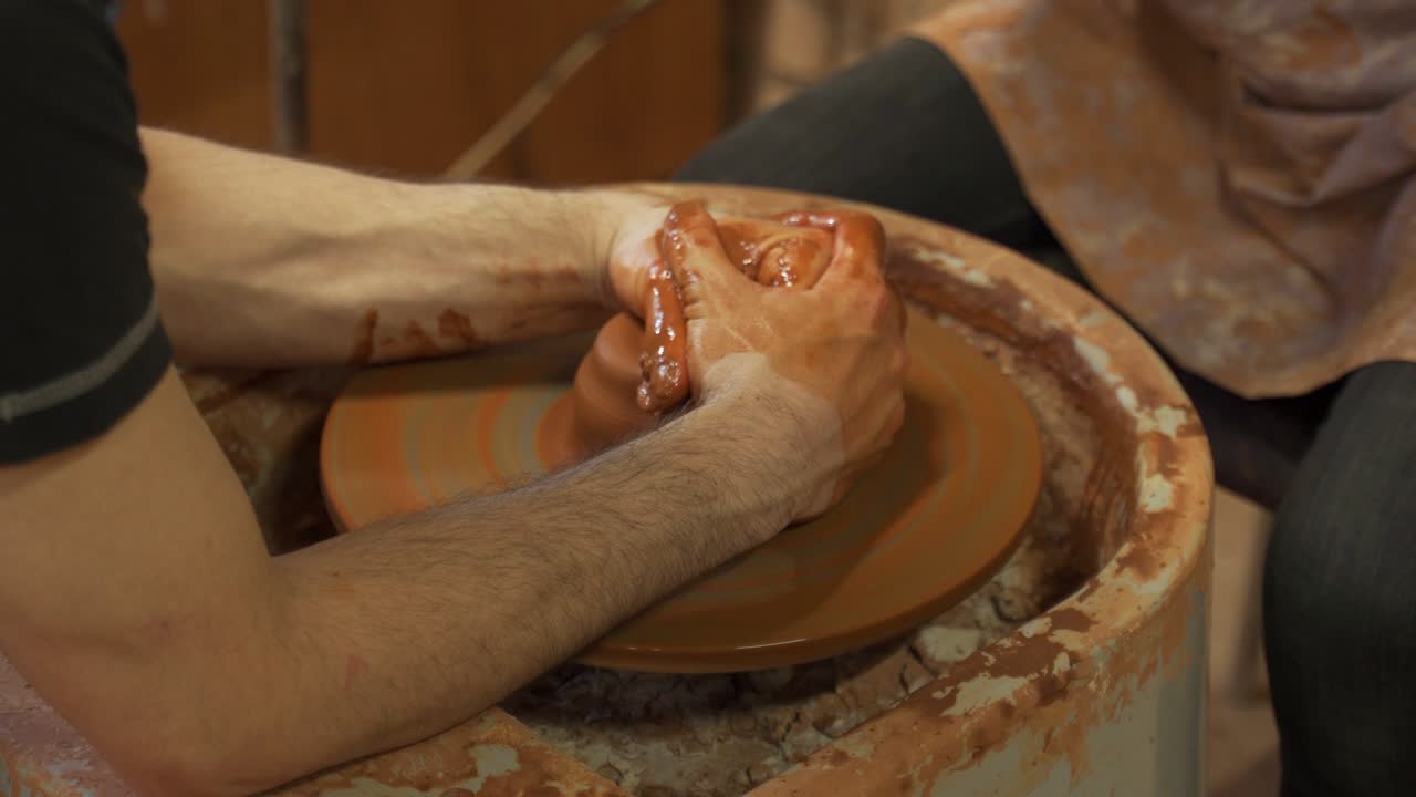 Vasaio che insegna l'arte della ceramica a una donna. Donna che lavora al tornio da vasaio