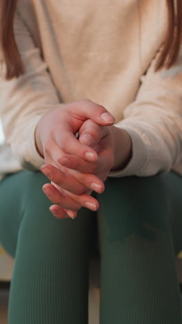 mujer se sienta con los dedos cruzados en las escaleras. mujer joven se siente nerviosa acerca de los eventos futuros mientras pasa tiempo a solas. estado nervioso y deprimido