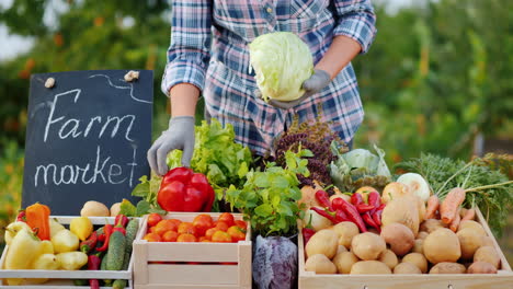 granjero vendedor pone repollo en el mostrador en el mercado de verduras
