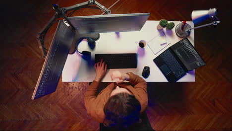 Top-down-view-of-self-employed-man-doing-IT-support-job,-drinking-coffee