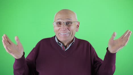 bald senior man in eyewear spreading hands and smiling with delight