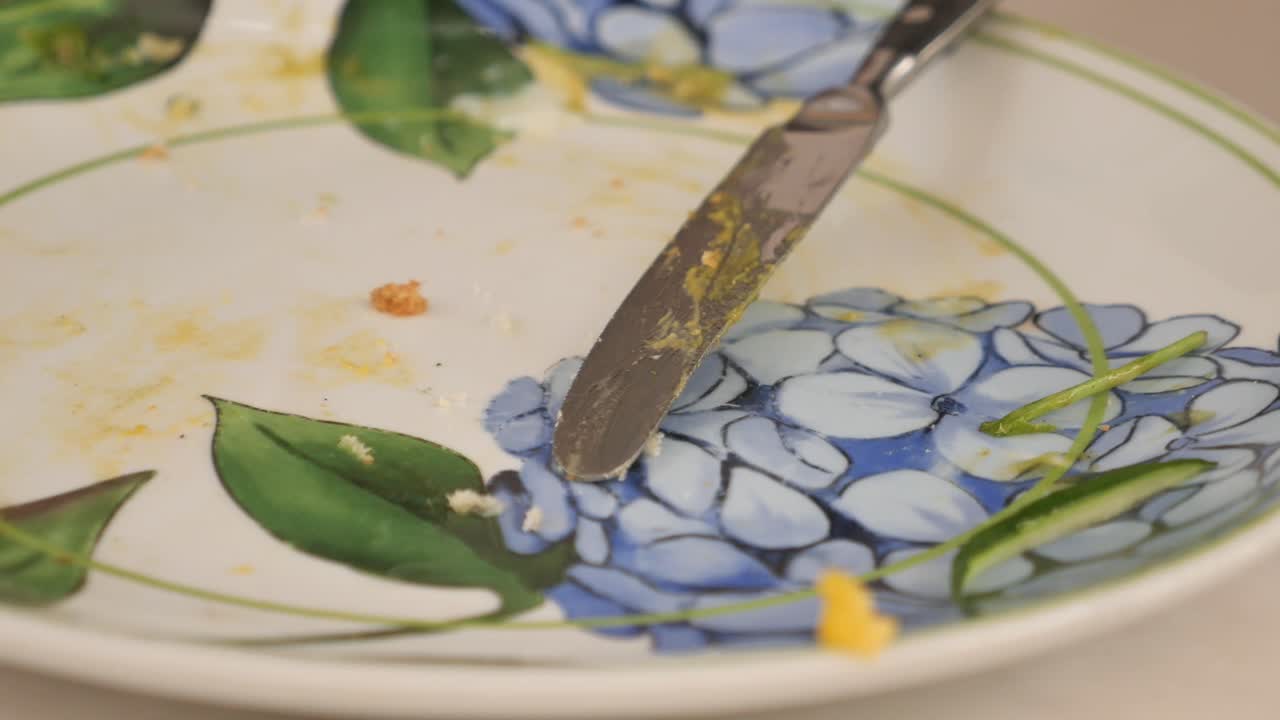Empty plate with leftovers and a knife