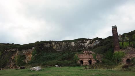 Porth-Wen-aerial-panning-across-abandoned-Victorian-industrial-brickwork-factory-remains-on-Anglesey-mountain-eroded-coastline