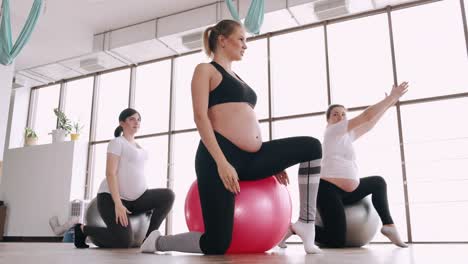 pregnant women are doing prenatal exercises on fitness balls in a gym