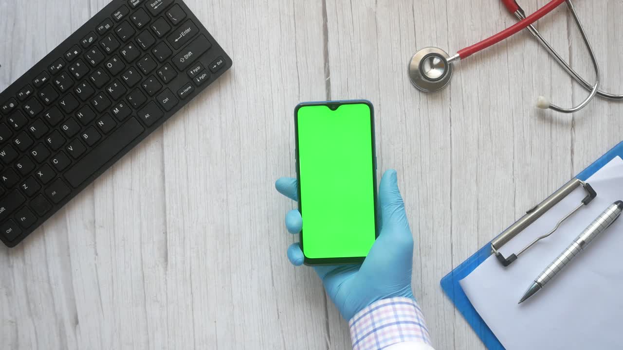profesional médico que utiliza un teléfono inteligente con pantalla verde