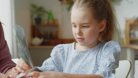 Little Girl Decorating Easter Egg with Mother