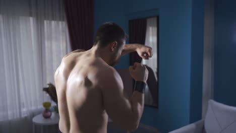 Ambitious-and-dynamic-boxer-shadow-boxing-with-his-back-turned.