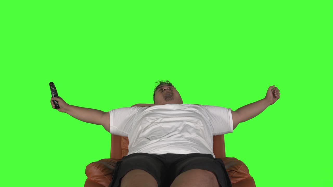 Homem acima do peso alongando os braços enquanto assiste TV