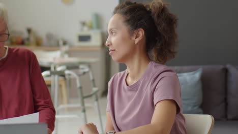 elderly man discussing papers with caregiver